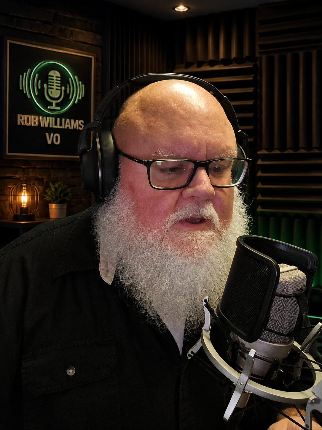 Rob Williams smiling at the microphone under the ON AIR sign